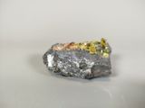 a small piece of silver and gold on top of a rock