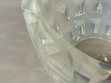 a clear glass bowl with a silver lid on a table