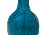 un vase bleu posé sur une surface blanche