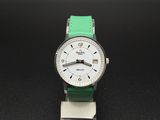 une montre blanche avec un bracelet vert sur un fond noir