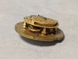 a close up of a gold pocket watch on a table