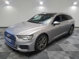 Une Audi argentée est garée dans une pièce au sol à carreaux.