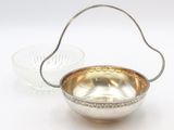 an image of a silver bowl and a glass bowl on a white surface