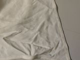 a white t - shirt laying on a table next to a pair of scissors