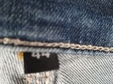 a close up of a pair of jeans with a tag on it