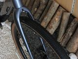 a bike parked next to a pile of logs