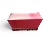 pink and red box on a white surface with a red fringe