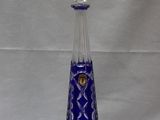 une image représentant un vase en verre bleu orné d'un couvercle en argent