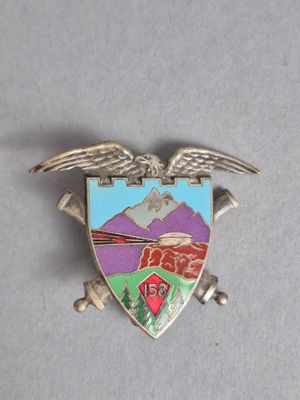 une image représentant un insigne métallique avec un aigle et une montagne en arrière-plan