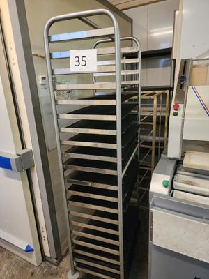 an image of a kitchen with a metal rack with trays of food