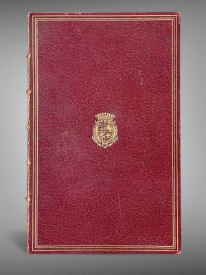 un livre rouge orné d'un emblème doré sur la couverture