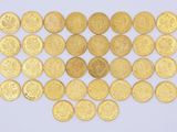 une pile de pièces d'or posée sur une surface blanche