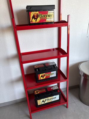 a red shelf that has a bunch of items on it
