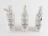 three wine bottles that have been wrapped in white paper