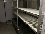 shelves in a commercial kitchen with tiled floors and tiled walls