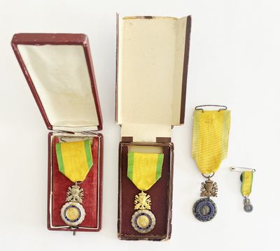 deux médailles et une médaille se trouvent dans un écrin posé sur une surface blanche