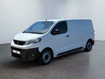 La petite camionnette blanche est garée dans une grande pièce.