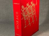 a red book with gold foil on it sitting on a table