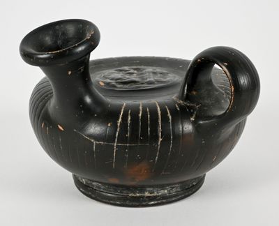 a black vase that is sitting on a white surface