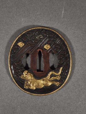a picture of a gold and black tsubai with a lion on it
