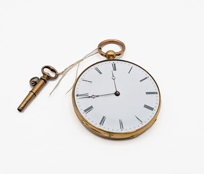 une montre de poche et une clé posées sur une surface blanche