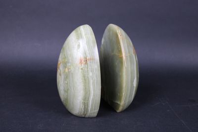 two pieces of green jade on a black background