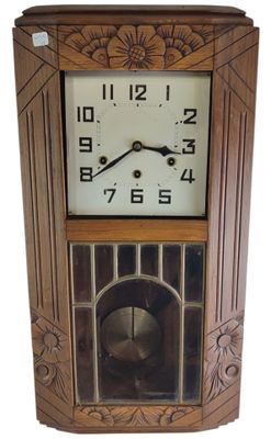 une image représentant une horloge en bois posée sur un mur blanc
