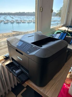 the printer is sitting on the table by the window