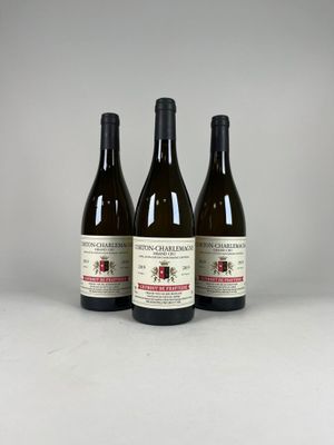 trois bouteilles de vin posées sur une table l'une à côté de l'autre
