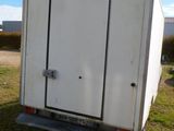 a white trailer that is parked in the grass