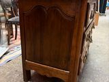 a wooden chest of drawers in the middle of a room