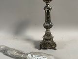 un bougeoir en argent et un couteau posés sur une table