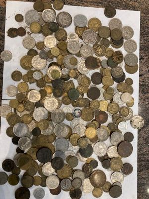 un tas de pièces de monnaie posées sur une table, à côté d'une paire de ciseaux