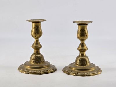 pair of antique brass candlesticks on a white background