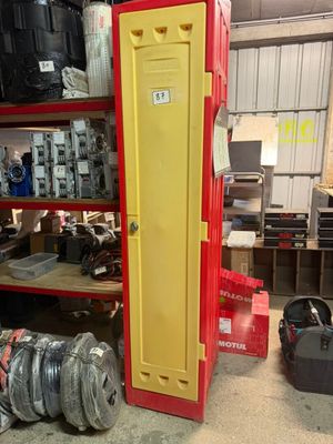 un casier rouge et jaune dans un garage où se trouvent de nombreux autres objets