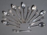 un grand nombre de cuillères et de fourchettes en argent disposées en cercle