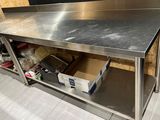 une table de travail en acier inoxydable avec une étagère en dessous
