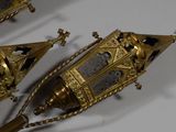 three gold colored clocks on a white table