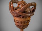 a wooden vase with a snake on top of it