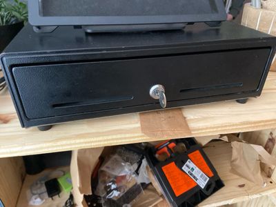 a black cash register sitting on top of a wooden shelf