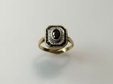a close up of a gold ring with a black stone in it