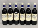 six bottles of wine are lined up in a row on a table