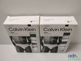 two boxes of calvin klein underwear sitting on top of a table