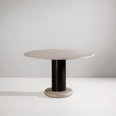 une table blanche avec un piètement noir et un plateau rond
