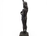 statue of a woman standing on a rock with her hands in the air