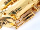 the saxophone is shiny gold and has a black knob