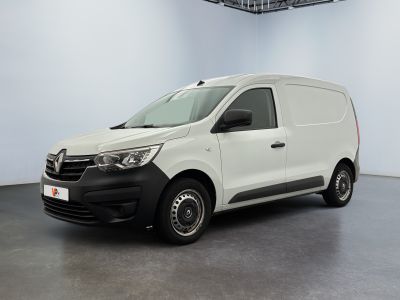 La camionnette blanche est garée dans une grande pièce.
