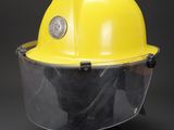 a close up of a yellow hard hat with a clear face shield