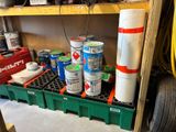 de nombreux pots de peinture posés sur une étagère dans un garage
