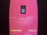 a pink surfboard sitting on top of a black surface